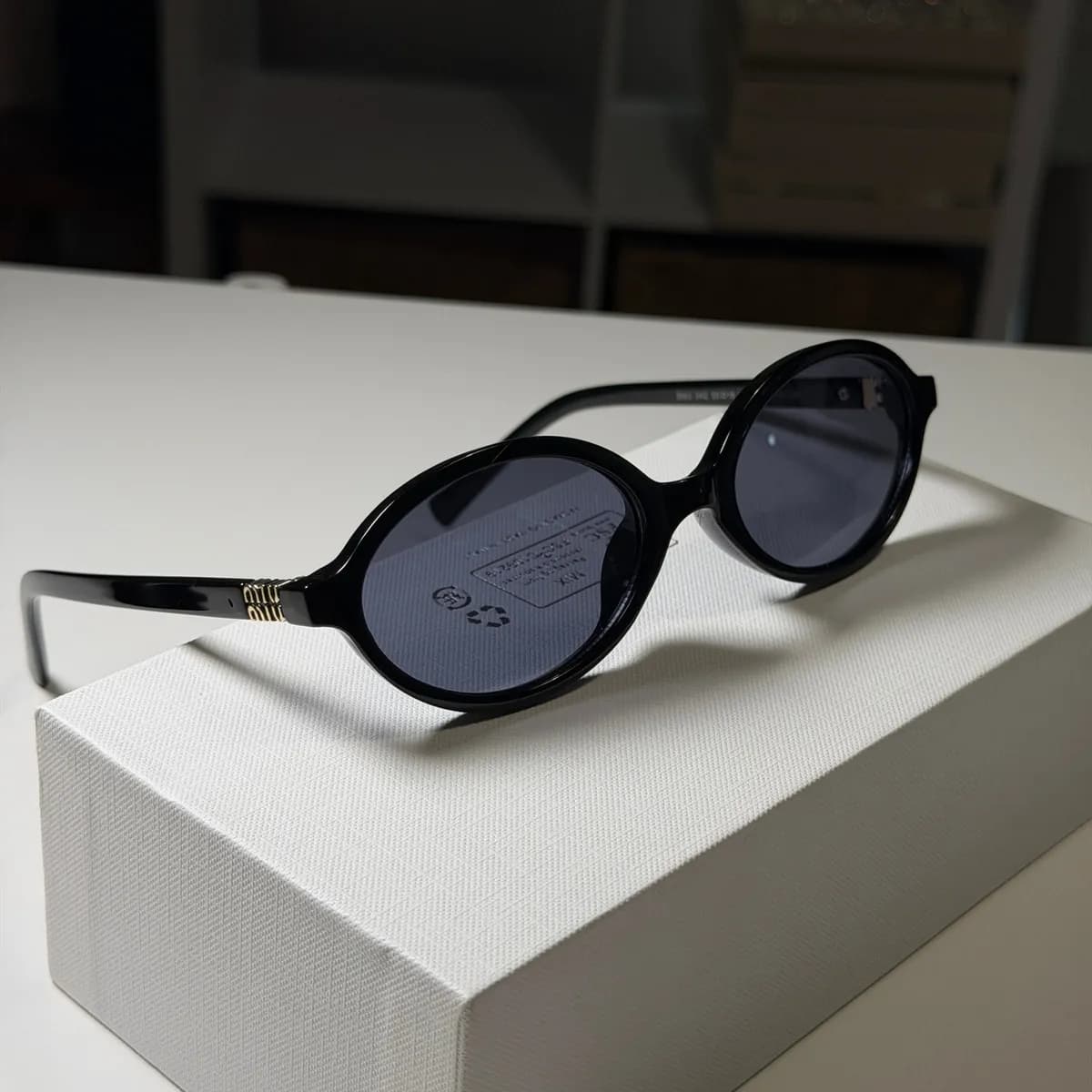 Oval Redondo, Preto, Detalhe Dourado, Lente Cinza